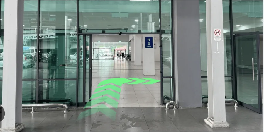 Interior of the car park entrance with arrows curving to the right towards the e-hailing area.